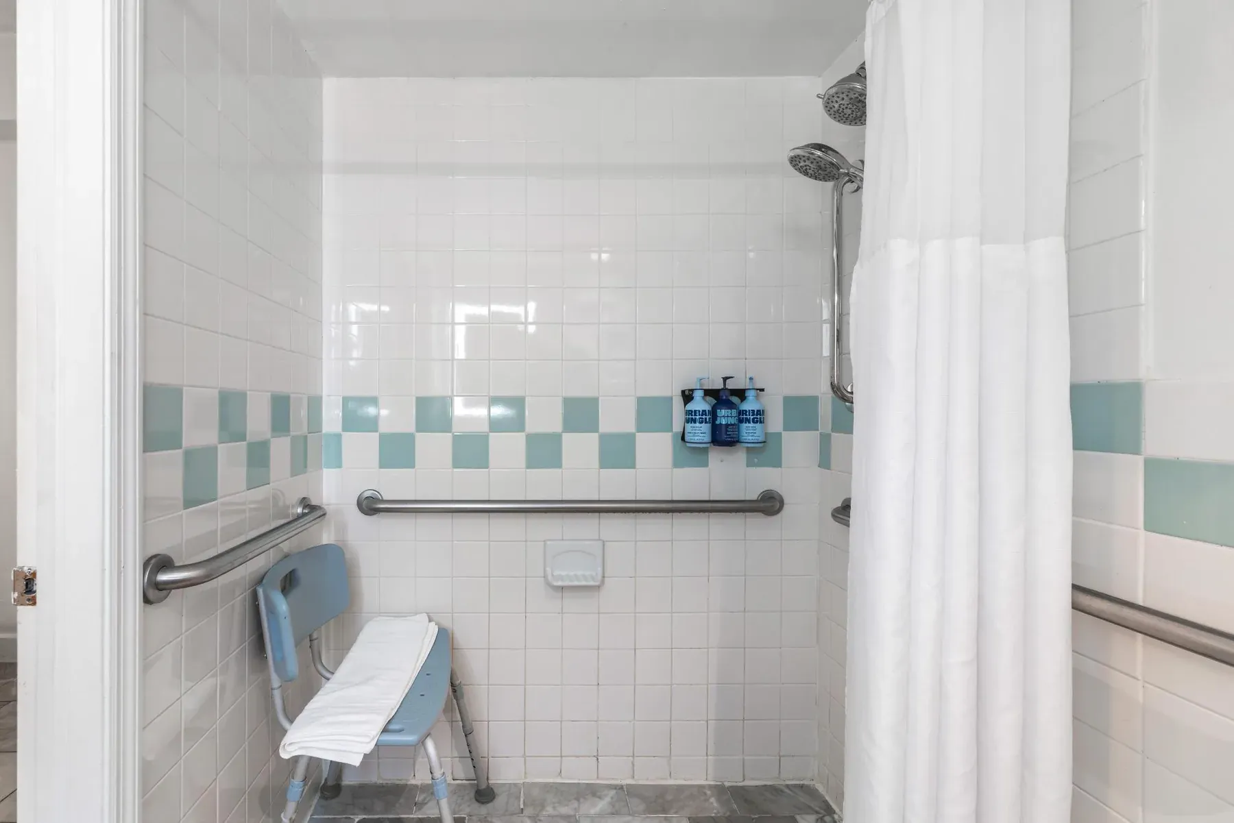 The roll-in shower, fold-down shower seat and grab bars on two walls