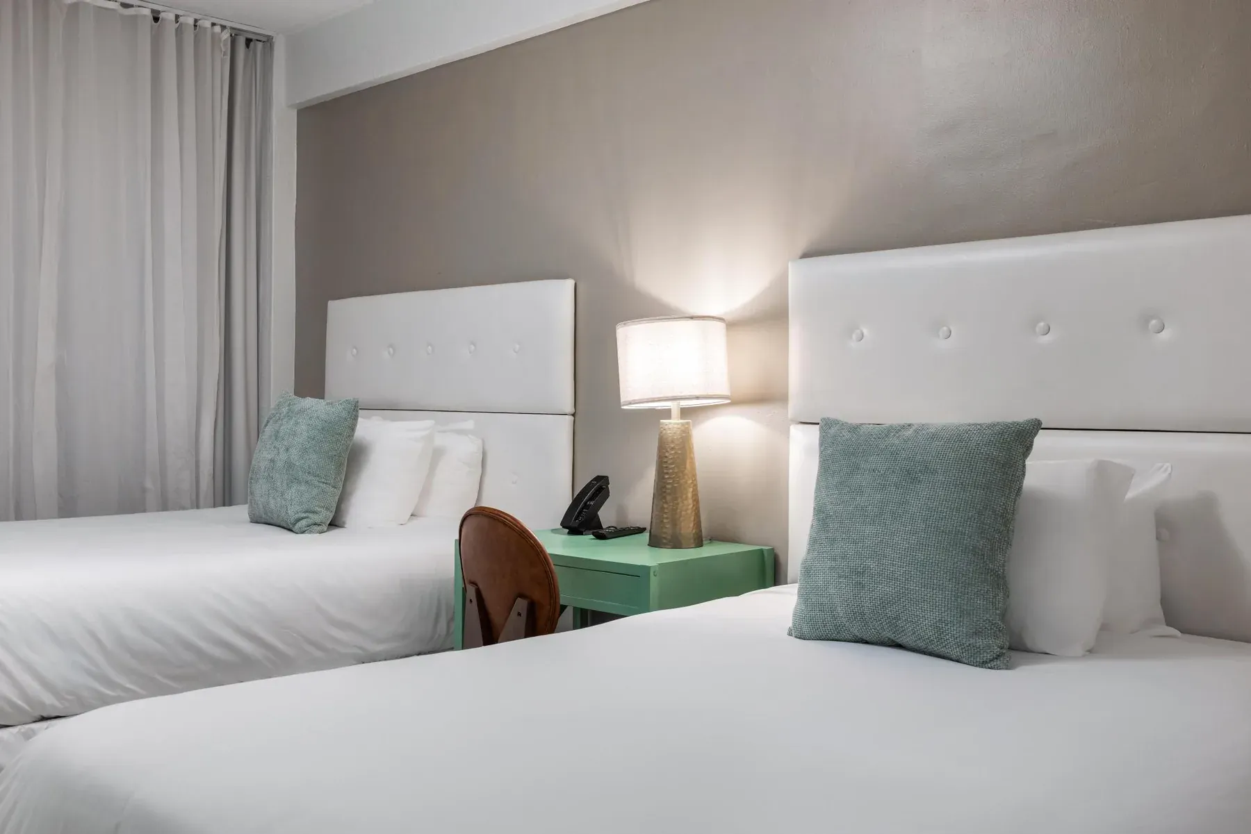 The two double beds with bedside lamp and green side table