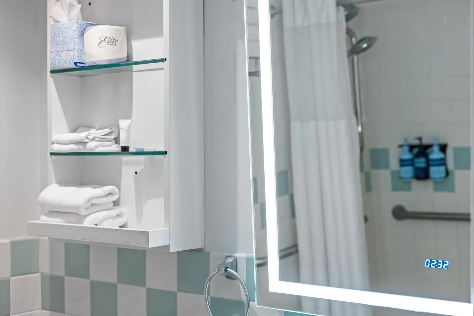 Bathroom detail, towel shelves and the lit mirror above the basin