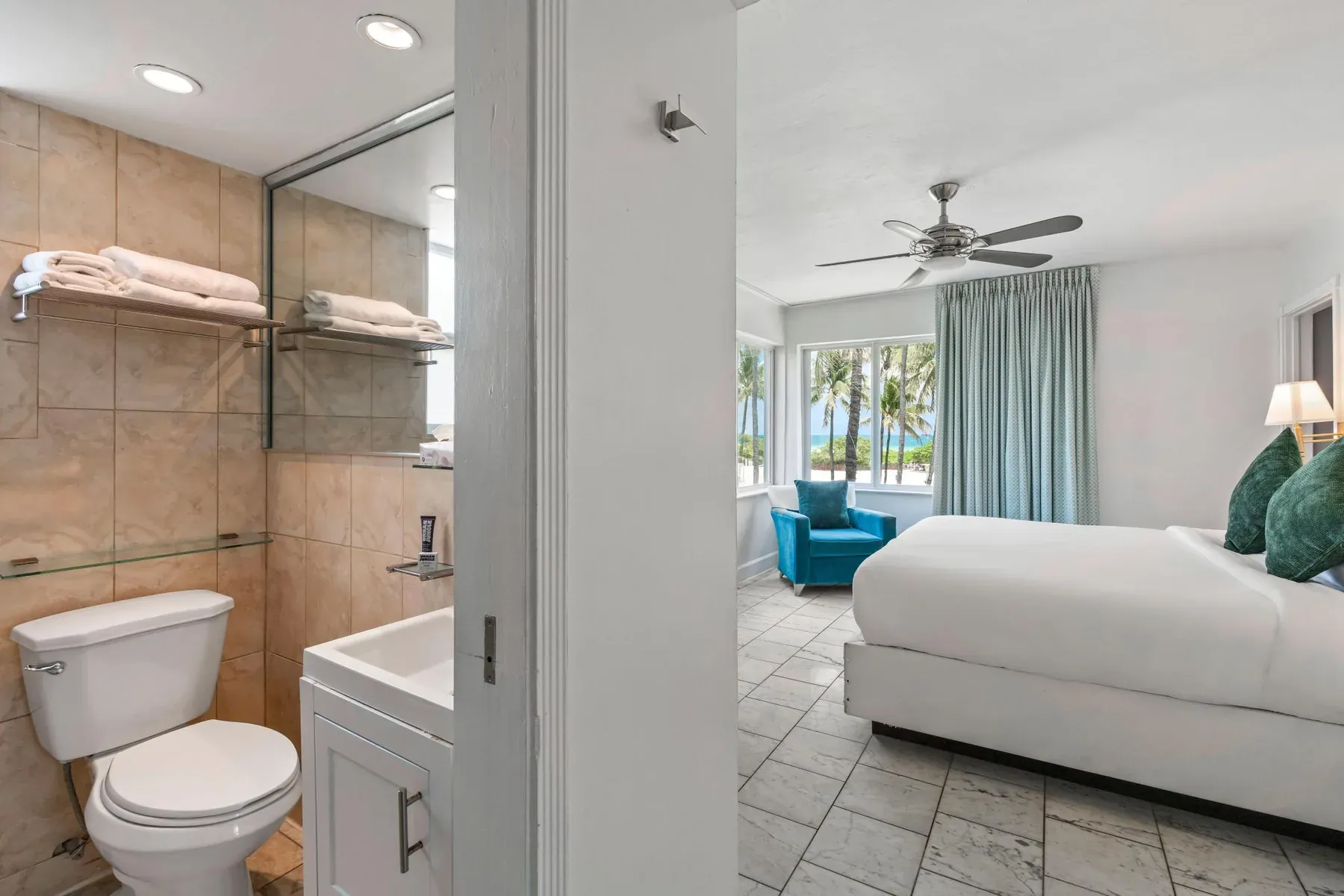 The bathroom looking through the open door to the bed and the windows