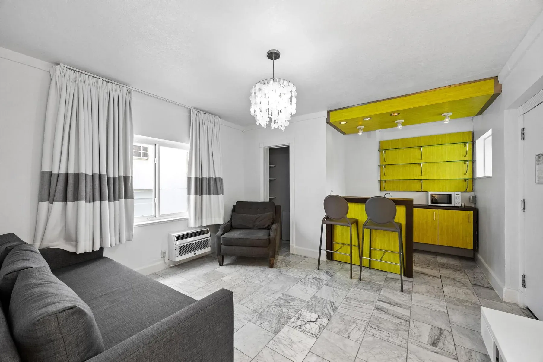 The suite’s separate living room, sofa and armchairs beside the kitchenette